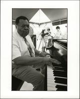 Jay McShann playing piano under a tent
