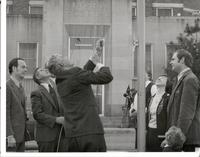 Richard Bolling raising a flag at building dedication