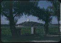 Hiller 08-062: View of a white building with a pointed top, framed by trees, Peiping