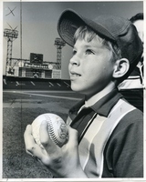 Child Holding Baseball at Clinic